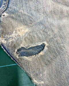 破れを補修したデニムパンツの修理部分